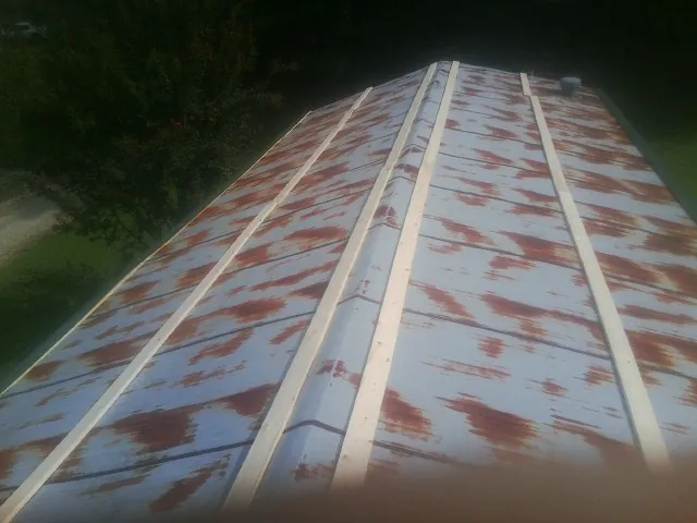 Rusted metal roof panels with new wood purlins before replacement — Storm Damage Roof Repair in Holt by Roofing Brothers